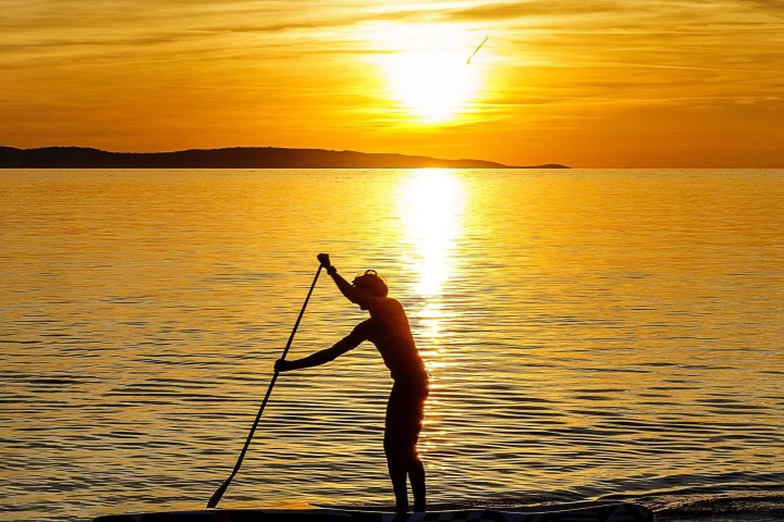 paddling at the sea during sunset