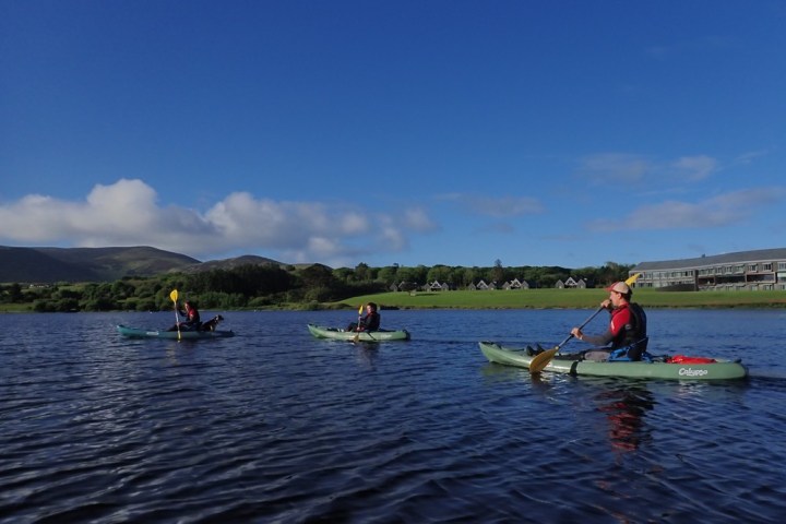 a group of people riding on the back of a boat in the water