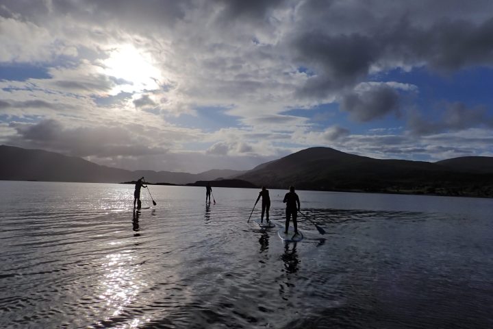 a group of people standing next to a body of water