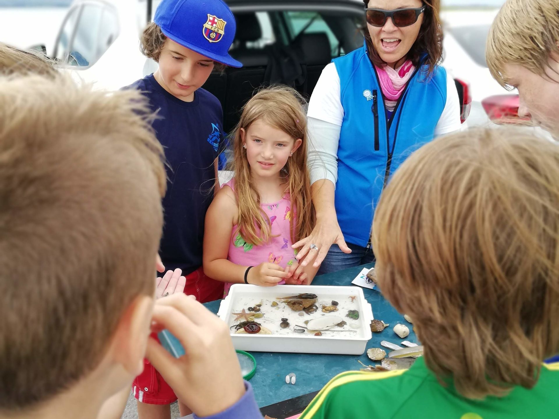 Morgana Davies et al. standing in front of a car