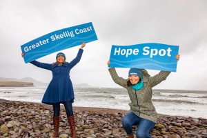 a person holding a sign on a beach