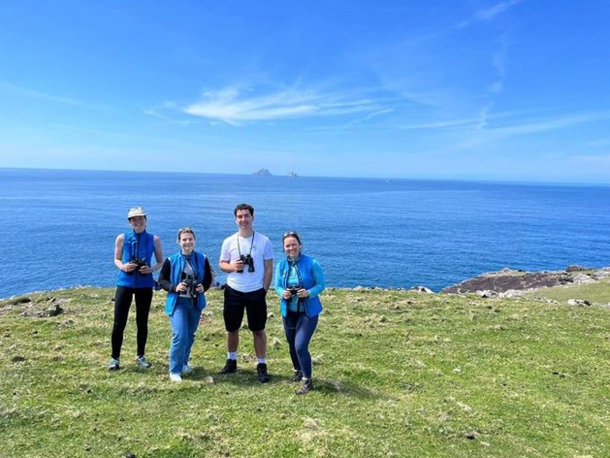 a group of people standing next to a body of water